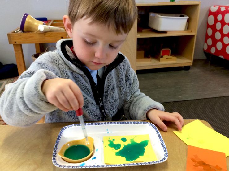 Boy doing coloured water job in playgroup